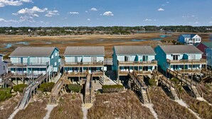 A coastal hotel with multiple buildings connected by wooden walkways. - "Beach Time"  Oceanfront 3 bedroom 3 bath duplex (Holden Beach)