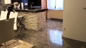 Una cocina moderna con una isla central, electrodomésticos integrados y una zona de comedor con sillas.