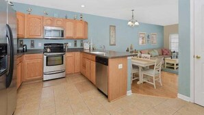 A kitchen with wooden cabinets, a microwave, an oven, and a dishwasher.