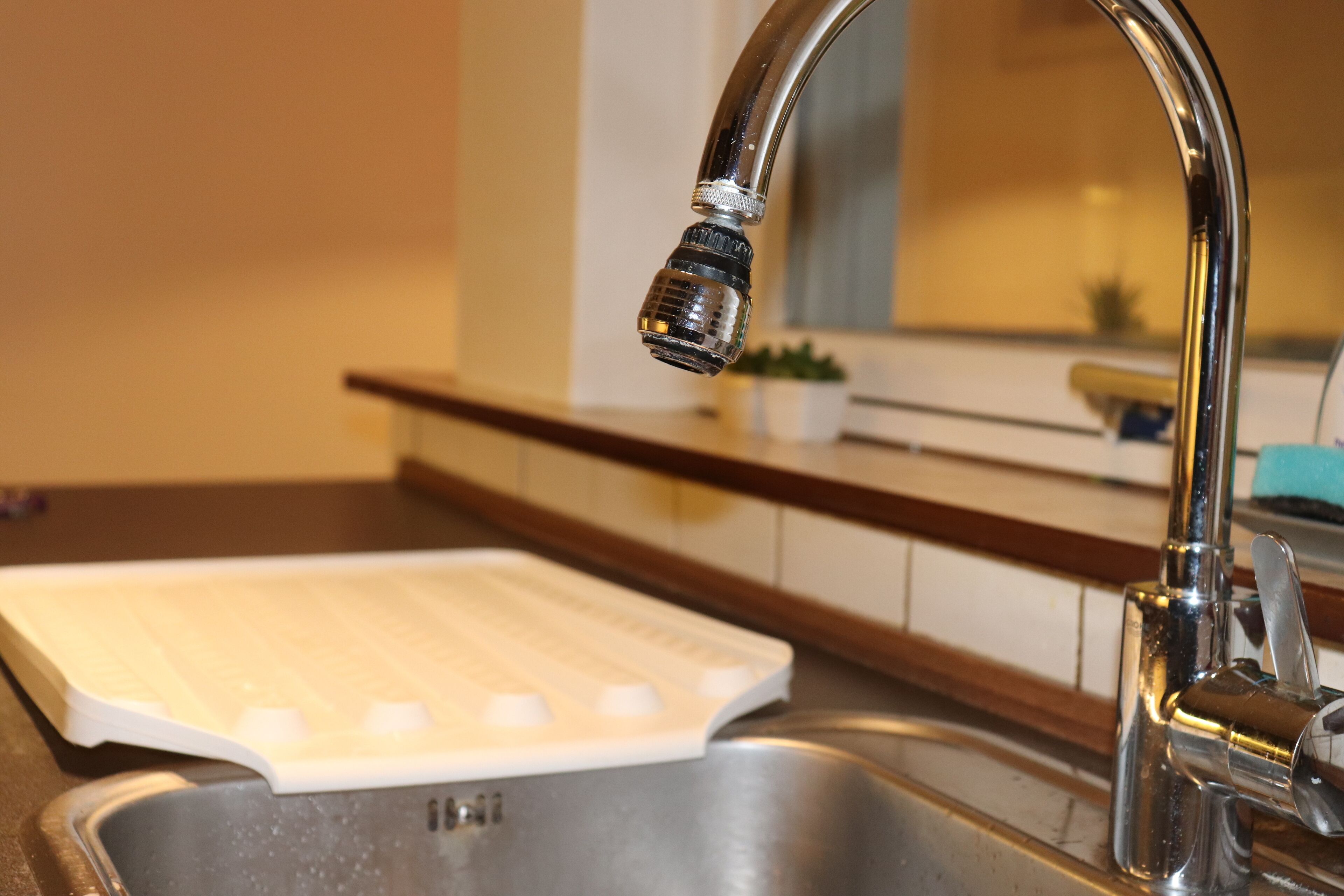 A kitchen sink with a faucet and a dish rack.