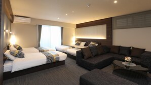 A hotel room with two beds, a sofa, a coffee table, and a large window. - GRAND BASE Hakata (Fukuoka)