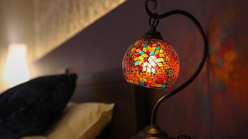 A mosaic lamp on a bedside table in a dimly lit room.