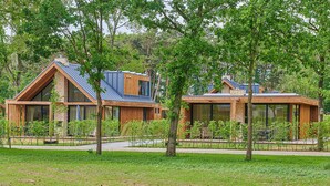 A modern two-story house with a sloped roof, large windows, and a wooden exterior. - Eagle 8p - Four Bedroom Villa, Sleeps 8 (Oosterhout)