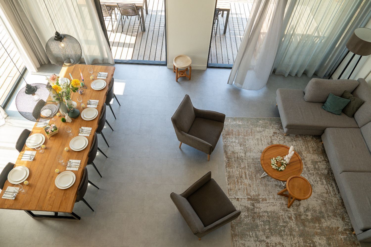 A spacious living area with a dining table set for four, a sofa, and a coffee table.