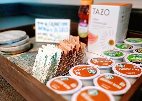 Un plateau contenant différentes sortes de dosettes de café et une boîte étiquetée « TAZO ».