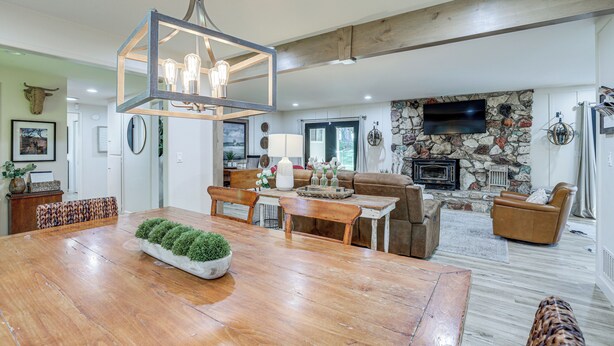 A spacious living room with a stone fireplace, a wooden dining table, and a comfortable seating area. - 3 Mi to Golf & Wineries: Arroyo Grande Home! (Arroyo Grande)