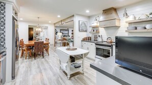 A modern kitchen with a dining area, wooden flooring, and built-in appliances. - 3 Mi to Golf & Wineries: Arroyo Grande Home! (Arroyo Grande)