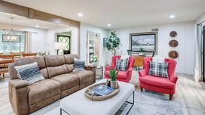 A living room with a brown sofa, a red armchair, and a coffee table with a book and remote control. - 3 Mi to Golf & Wineries: Arroyo Grande Home! (Arroyo Grande)