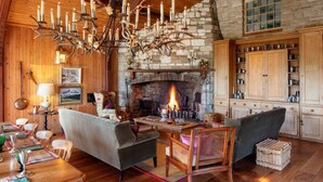 A cozy living room with a fireplace, wooden furniture, and a chandelier. - 4 bedroom stunning rural position near Jurassic coast ! (Dorchester)