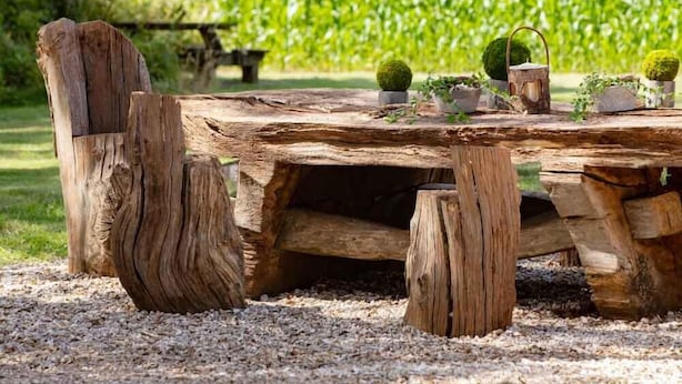 A rustic wooden table set outdoors with a view of a green field and a tree in the background. - 4 bedroom stunning rural position near Jurassic coast ! (Dorchester)