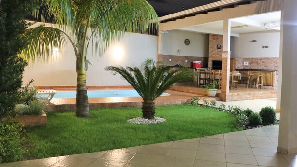 A pool area with palm trees and a patio.