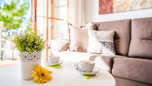 Uma sala de estar acolhedora com um sofá, uma mesa de centro e um vaso de planta.