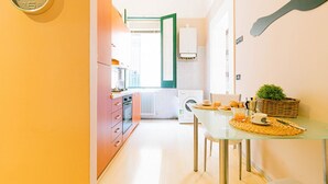 Eine moderne Küche mit Essbereich, einer Uhr an der Wand und einer originellen Wanddekoration.