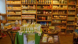 Een winkel met schappen vol met diverse verpakte producten, waaronder levensmiddelen en persoonlijke verzorgingsartikelen.