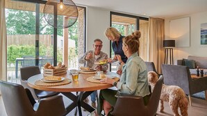 Un espace repas comprenant une table ronde, des chaises et un luminaire suspendu.