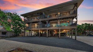 A multi-story building with balconies, numbered rooms, and a gravel driveway.