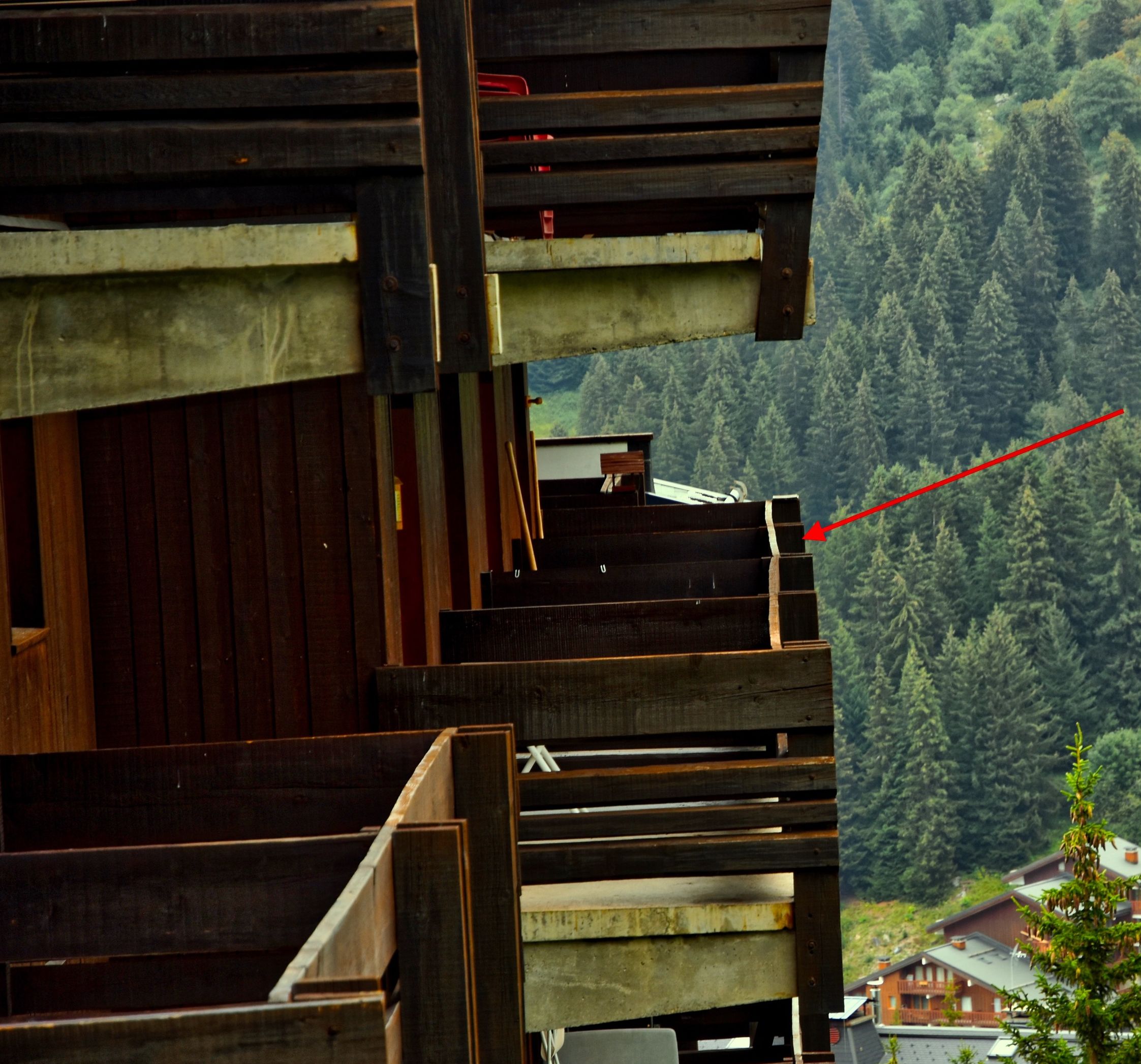 Vista de uma área arborizada com um edifício ao longe, com a inscrição 'NOTRE APPARTEMENT'.