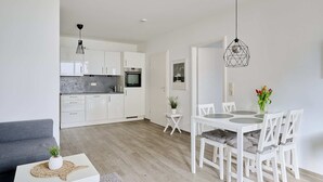 A modern apartment with a kitchen, dining area, and living room.