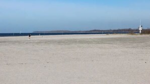A beach with a lighthouse in the distance.