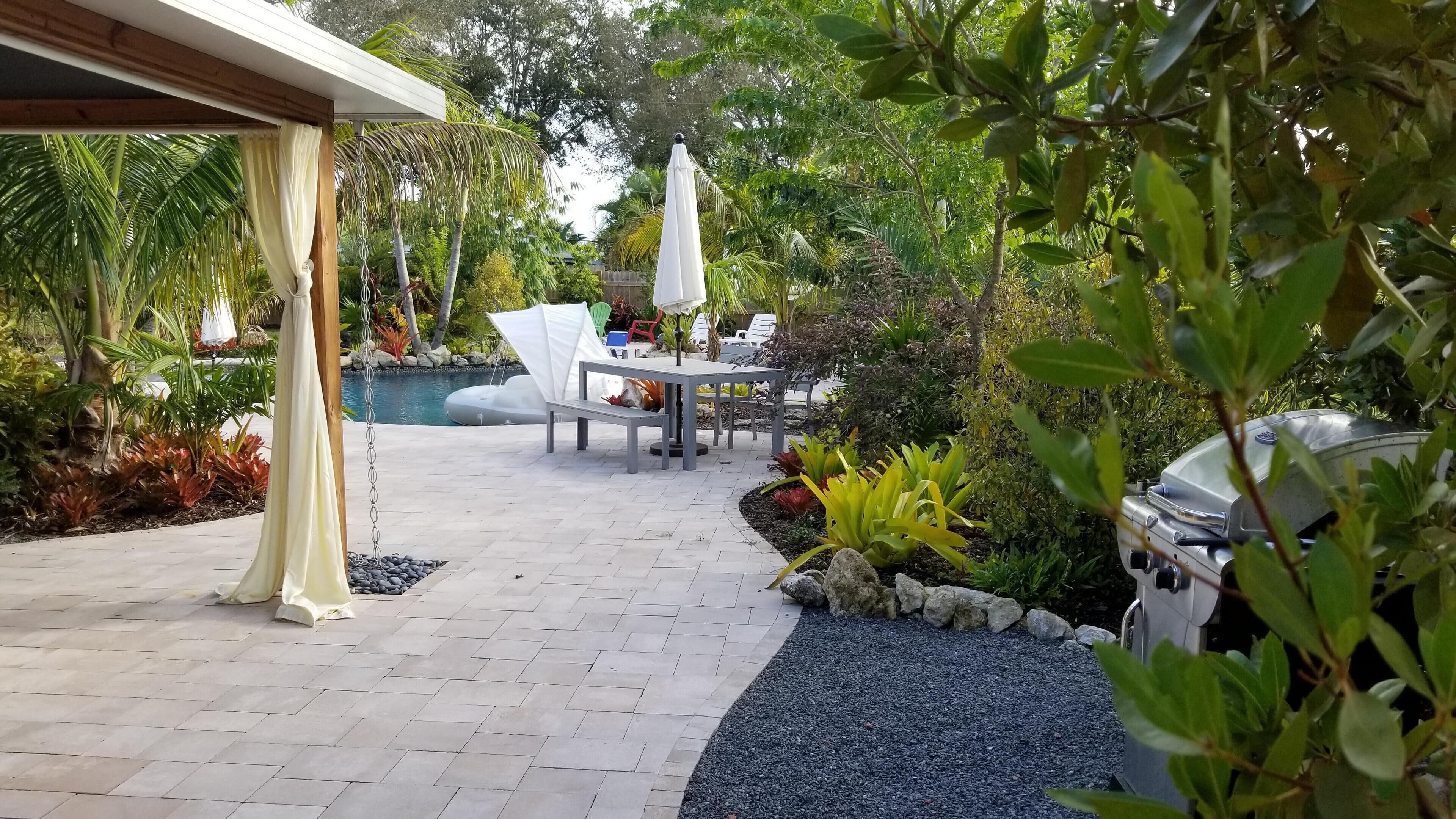 Un espace extérieur aménagé avec une piscine, du mobilier de jardin et un barbecue.