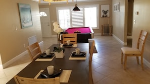 A dining area with a rectangular table, chairs, and a decorative centerpiece.