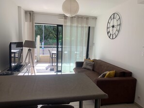 A modern living room with a sofa, a table, and a tripod lamp.