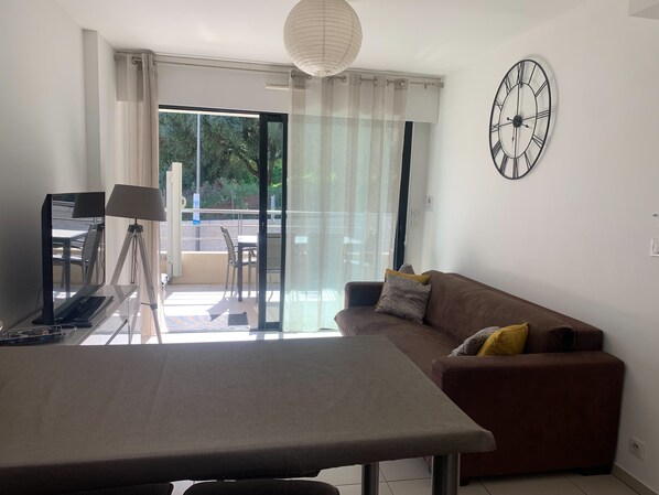 A modern living room with a sofa, a table, and a tripod lamp.