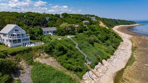 Una propiedad costera con varias casas, una playa y un litoral rocoso.