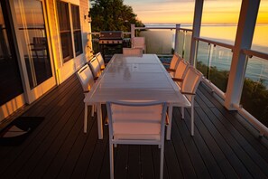 Une terrasse avec une table et des chaises, donnant sur un plan d’eau.