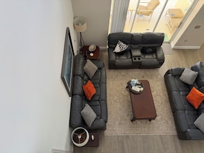 A modern living room with a sectional sofa, a coffee table, and a side table with a lamp.