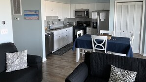 Un espacio habitable compacto con kitchenette, comedor y asientos.