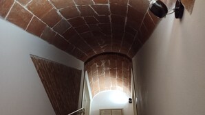 Un escalier avec une arche en briques et une main courante.