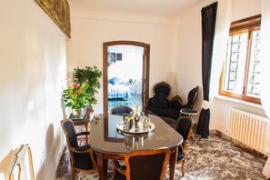 Un comedor con una mesa, sillas y una planta en maceta.