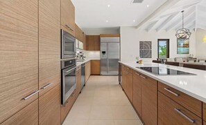 Uma cozinha moderna com armários de madeira, eletrodomésticos de aço inoxidável e uma ilha grande.