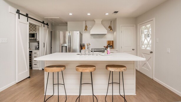 A modern kitchen with a central island, bar stools, stainless steel appliances, and pendant lighting. - Peaceful Lake Granbury Retreat - Private Dock (Granbury)