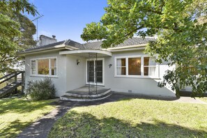 A two-story house with a front porch, a staircase, and a well-maintained lawn. - Charles (Lorne)