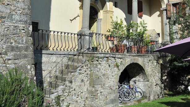 A historic building with a courtyard, stone arches, and a balcony with hanging plants. - VILLA BENEDETTA, Casa Marcello # 2 (Sillicano in Garfagnana, Italia)