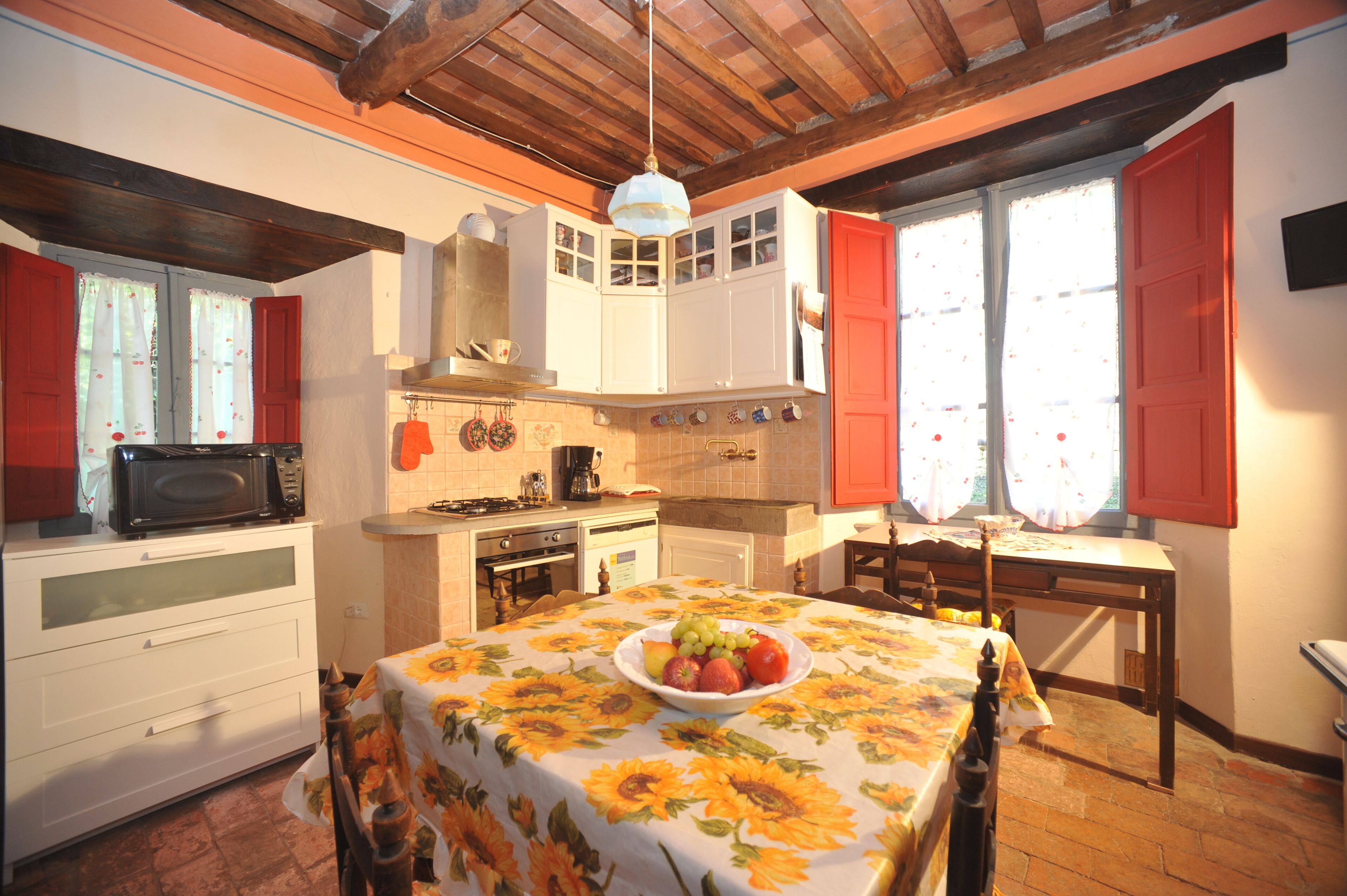 Una cocina con una mesa de comedor para dos personas, microondas y estufa.