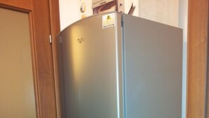 A compact kitchen with a built-in refrigerator and a white countertop. - New apartment 250 m from the beach (Alghero)