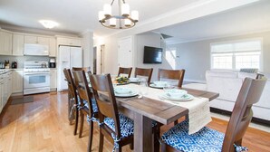 A dining area with a wooden table, chairs, and a chandelier.