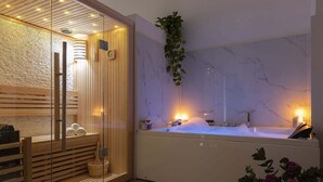 A spa room with a wooden sauna, a marble wall, a large bathtub, and a hanging plant. - Experience Collection by ROMAC Margana Palace w/ terrace & wellness (Roma)