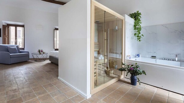 A modern bathroom with a glass shower enclosure, a white bathtub, and a marble wall. - Experience Collection by ROMAC Margana Palace w/ terrace & wellness (Roma)