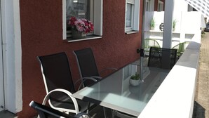 Une table avec des chaises et une fenêtre ornée de fleurs.