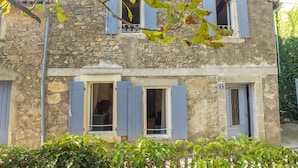 A stone building with blue shutters, a visible number '2' on the door, and a small balcony with a metal railing. - Quality charming house classified 3* with private pool and air conditionning (La Caunette)