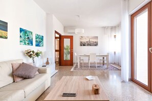 Ein modernes Wohnzimmer mit einer Couch, einem Couchtisch und Kunstwerken an den Wänden.