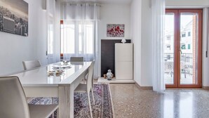 A modern kitchen with a dining table, chairs, a rug, and a view of the outside. - Di Palma 4 Family House - Lecce Selection (Lecce)