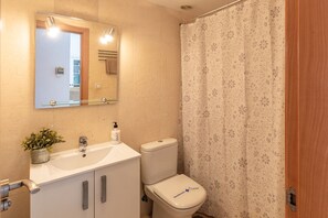Un baño con inodoro, lavabo y espejo.