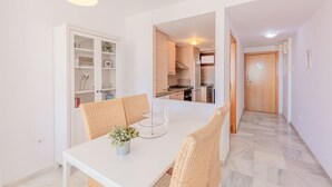 Eine moderne Küche mit weißen Schränken, einem eingebauten Backofen und einem Edelstahl-Kühlschrank.