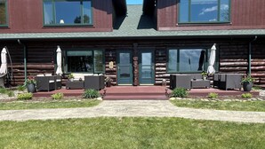 A log cabin with a front porch, outdoor seating, and a stone pathway leading to the entrance.