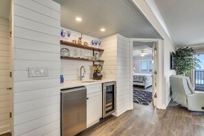 A modern kitchen with white cabinetry, a built-in dishwasher, and a countertop with decorative items.